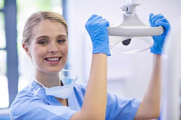 Female dentist bendigo holding the dental light