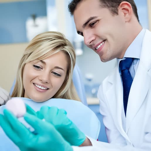 Male Dentist Bendigo explaining a dental procedure to a female patient