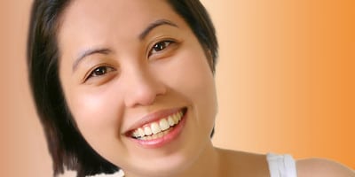 Young female showing her teeth after having braces treatment